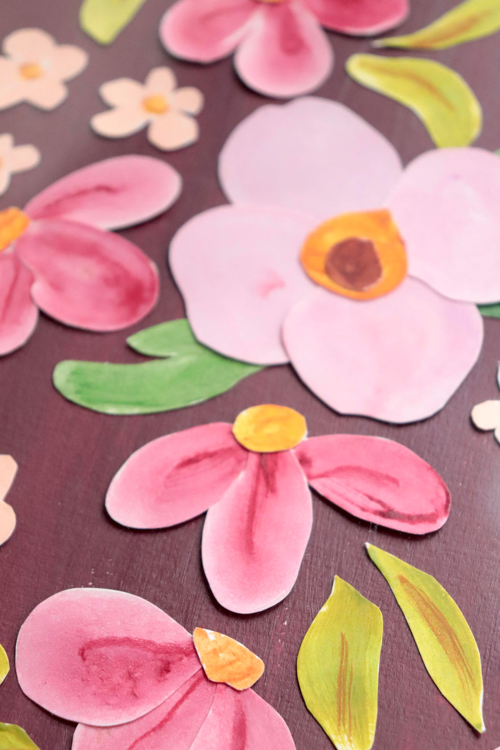 Grand herbier original A3 nommé Amarante, collage de fleurs en papier rose et blanc en relief sur fond peint bordeaux, encadré dans un cadre en bois rose, création Chemin des Marettes.