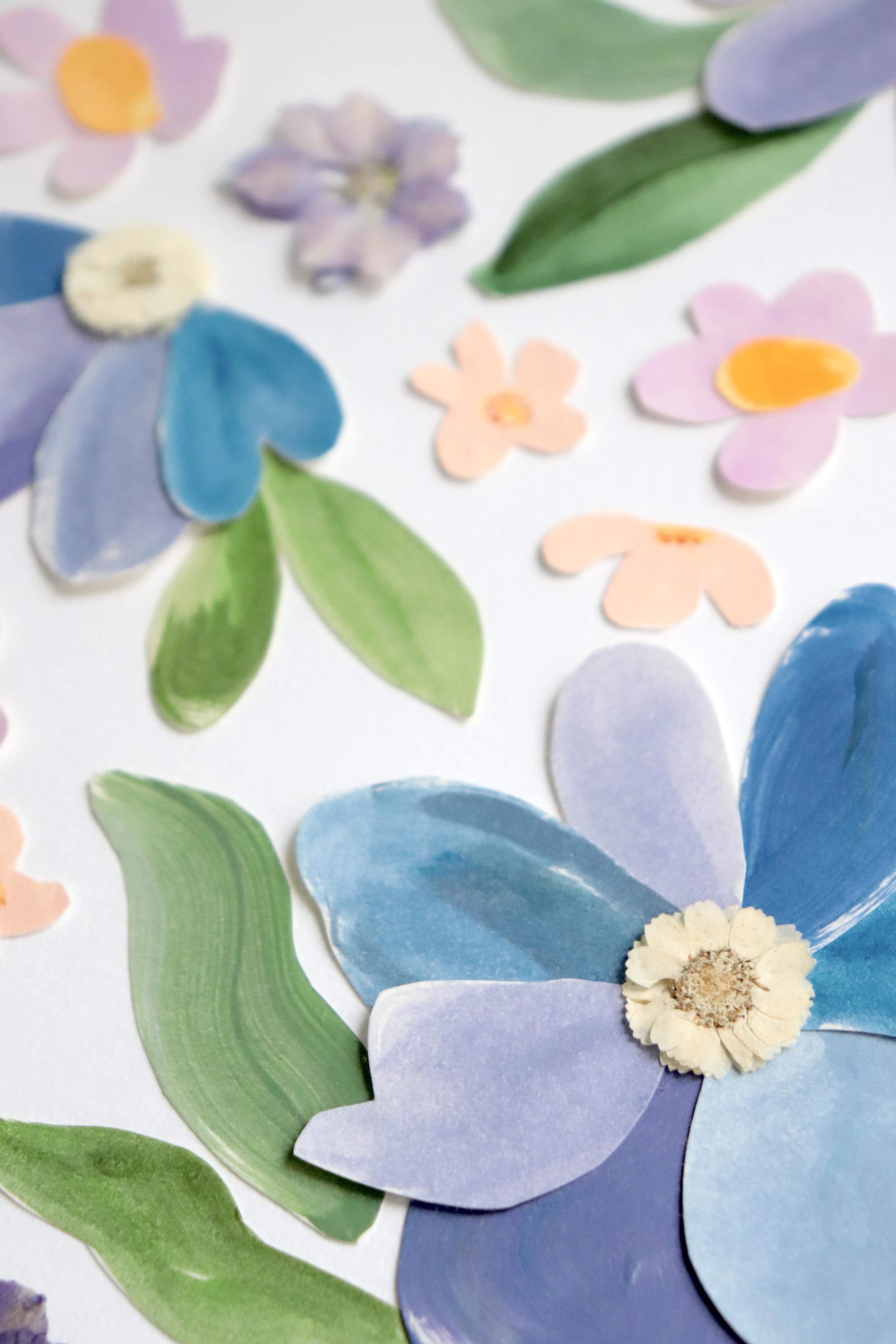 détails herbier original A4 nommé céleste, collage de fleurs en papier en relief et fleurs pressées sur fond blanc, encadré dans un cadre en bois bleu, création Chemin des Marettes.