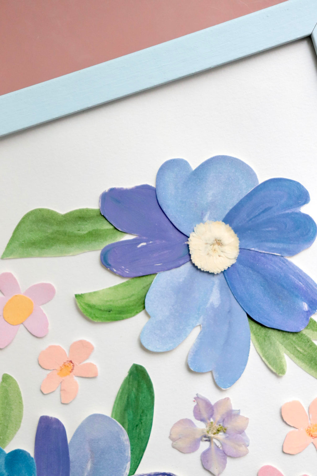 détails herbier original A4 nommé céleste, collage de fleurs en papier en relief et fleurs pressées sur fond blanc, encadré dans un cadre en bois bleu, création Chemin des Marettes.
