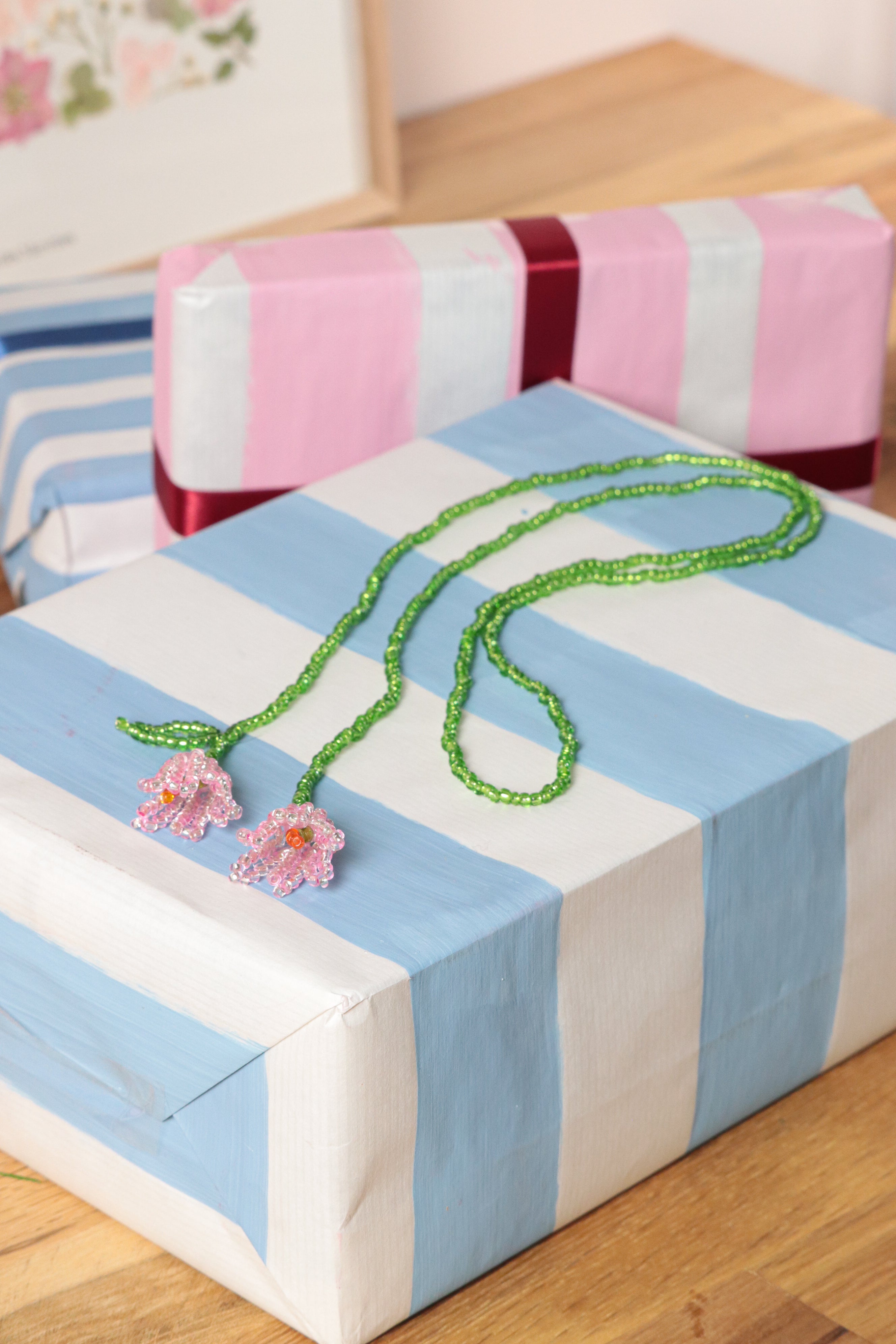 Collier sautoir tulipes en perles de rocailles roses avec pistil orange et feuille verte