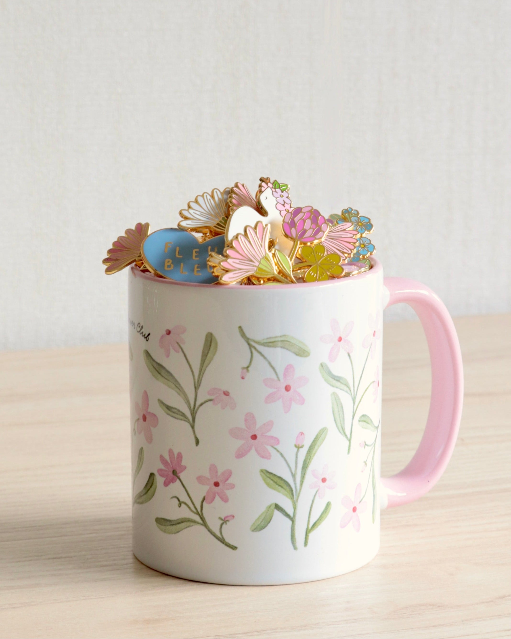 lot d'un mug fleuri et d'un pin's émaillé chemin des marettes