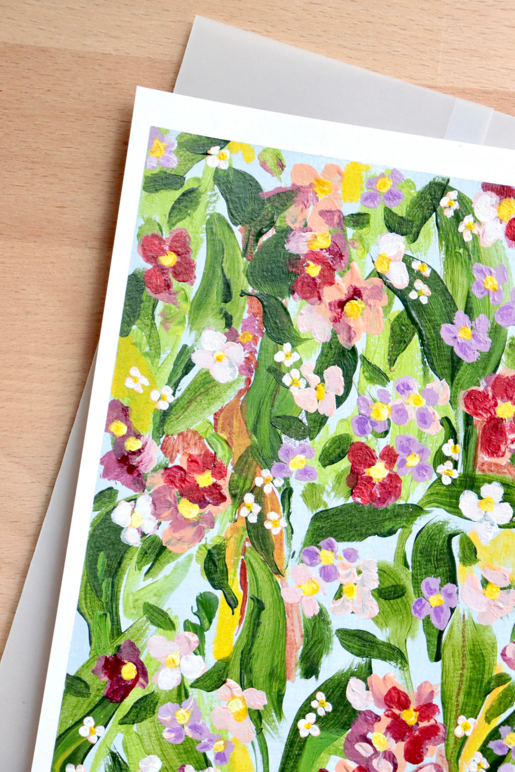 Mini peinture acrylique originale A5 nommée Rivage, par Chemin des Marettes. Fleurs blanches rouges et violettes et feuillage vert sur un fond bleu ciel doux. Style botanique aérien et poétique, idée cadeau pour la Fête des Mères.
