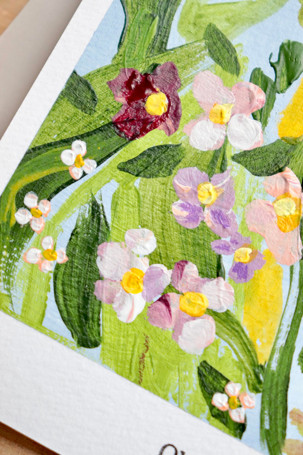 Mini peinture acrylique originale A5 nommée Rivage, par Chemin des Marettes. Fleurs blanches rouges et violettes et feuillage vert sur un fond bleu ciel doux. Style botanique aérien et poétique, idée cadeau pour la Fête des Mères.