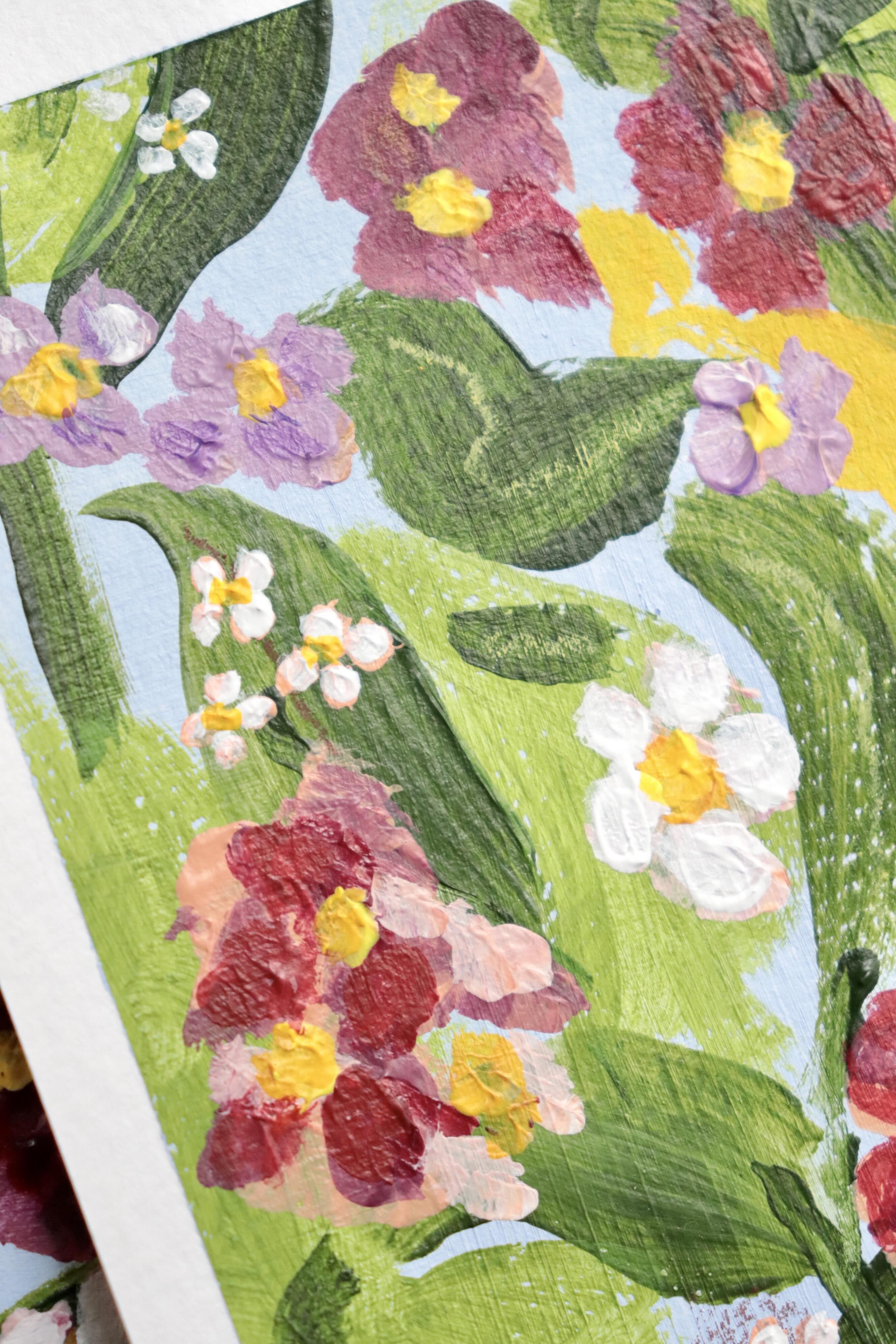 Mini peinture acrylique originale A5 nommée Rivage, par Chemin des Marettes. Fleurs blanches rouges et violettes et feuillage vert sur un fond bleu ciel doux. Style botanique aérien et poétique, idée cadeau pour la Fête des Mères.